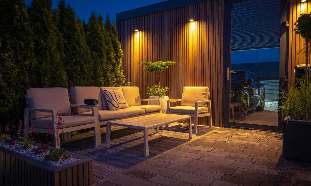 Stone patio in Madison with modern outdoor seating and warm night lighting, perfect for entertaining guests.
