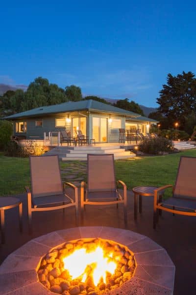 Stone patio with built-in fire pit and seating area in a Madison backyard, designed for outdoor entertaining.
