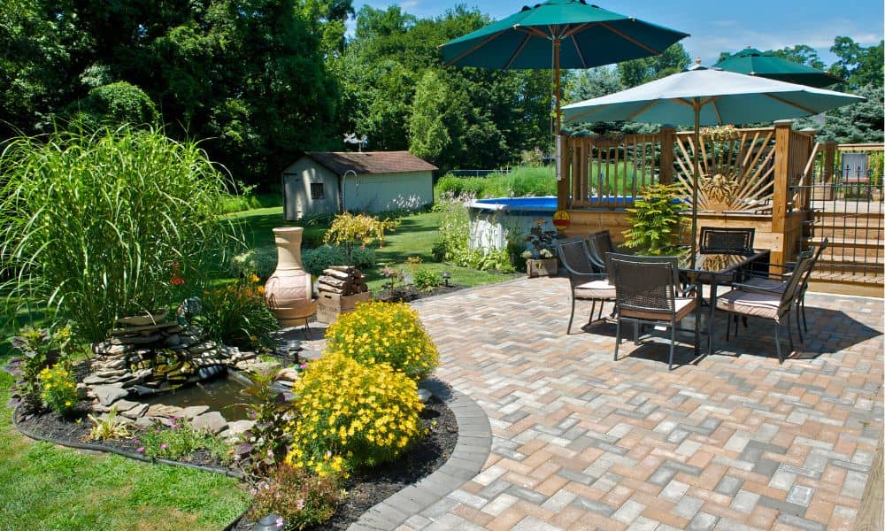 Backyard patio with stone pavers, outdoor seating, and garden landscaping
