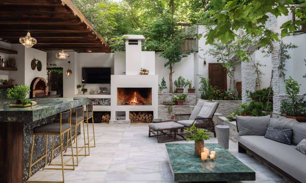 Outdoor fireplace built with stone and concrete on a stylish patio surrounded by greenery