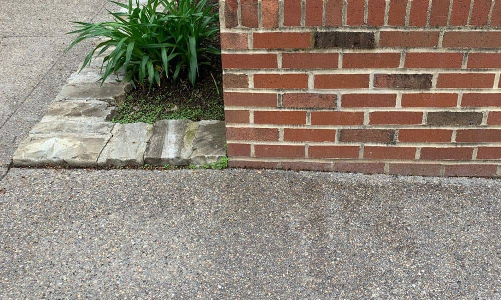 A brick retaining wall built beside a sidewalk showing proper height and placement for home safety