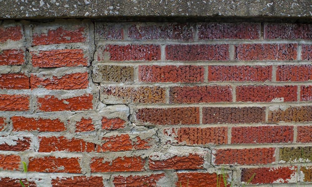 Small cracks on an exterior brick wall showing early signs that brick repair may be needed