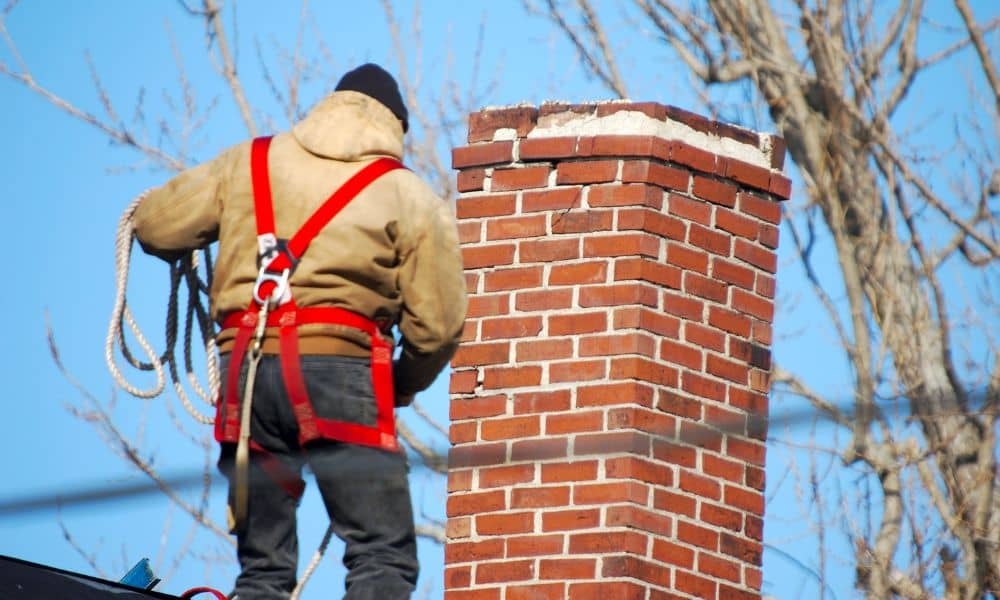 Stone masonry work on a residential chimney showing crown condition and repair access