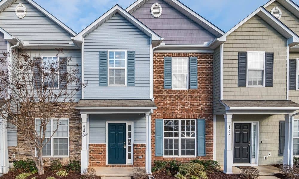 Residential townhomes with painted brick exteriors showing normal aging and well-maintained masonry surfaces