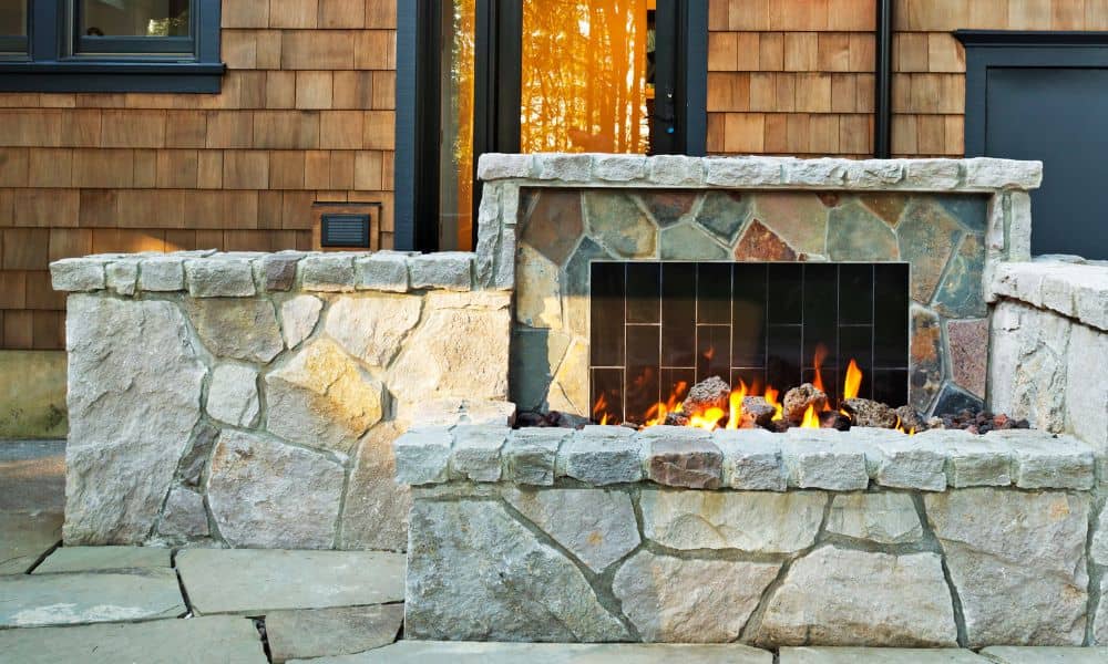 Stone outdoor fireplace with built-in firebox designed as a permanent backyard feature