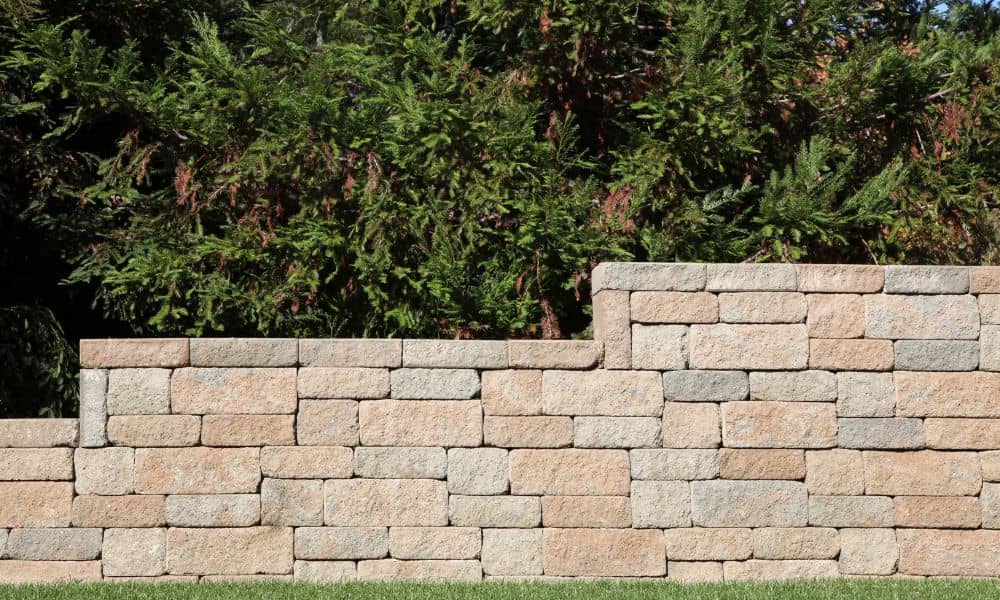 A newly built retaining wall with straight block lines and clean cap stones
