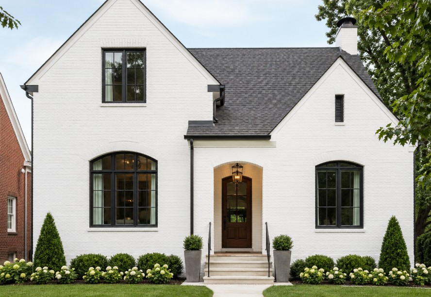 A residential home with a professional painted brick exterior in a matte white finish, featuring clean mortar lines and updated curb appeal.